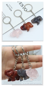 Detail of hand-carved natural crystal elephant keychains in rose quartz and agate stones