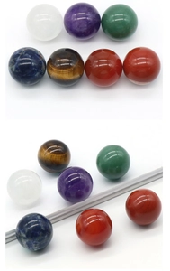 Detailed view of seven polished 25mm natural chakra crystal stones in various colors