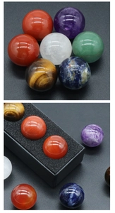 Macro detail of seven colorful natural chakra stone spheres in a black gift box