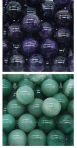 Macro shot of 25mm polished amethyst and aventurine chakra healing crystal spheres