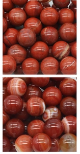Macro detail of 25mm Red Jasper and Red Agate chakra stones with polished texture