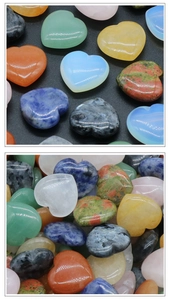 Macro detail of various polished 25mm natural crystal heart stones in a multi-color heap