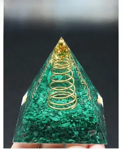Macro shot of malachite crystal orgone pyramid with gold foil and copper coil inserts