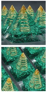 Detailed macro view of malachite orgone energy pyramid with gold leaf and copper spiral