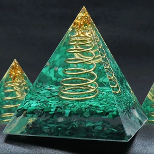 Green malachite orgone pyramid with gold foil and metal spiral in clear resin