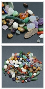 Close-up of polished natural crystal gravel and mixed gemstone chips on a dark background