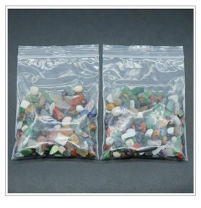 Macro shot of 100g bags containing colorful mixed natural crystal crushed stones