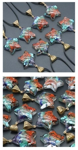Macro detail of pentagram resin pendant with natural chakra stones and metal spiral coil