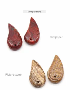 Detailed view of hand-carved red jasper and picture stone wing-shaped pendants