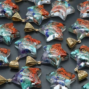 Star-shaped Orgonite resin pendant with natural crystals and copper coil on black background