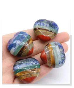 Detail view of four multi-layered chakra heart stones held in hand for size visualization