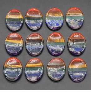 Detailed macro view of twelve oval rainbow chakra worry stones in a 3x4 grid arrangement