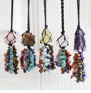 Detail of five handcrafted crystal gemstone necklaces with woven net pouches and tassels