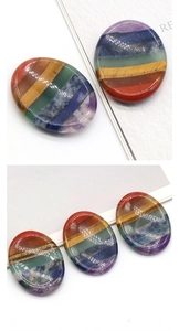 Macro detail of oval seven-layer chakra worry stone with polished natural crystal surface