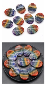 Macro view of polished oval 7 chakra stones featuring colorful natural quartz layers