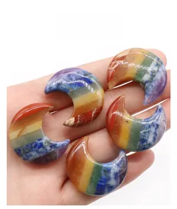 Detailed view of five handcrafted chakra crescent moon stones held in a hand