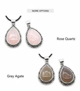 Detail view of rose quartz and grey agate water drop pendants with ornate metal frames