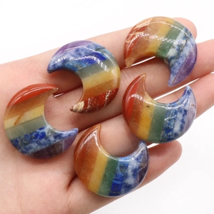 Hand holding seven layered chakra crystal moon stones for meditation and healing