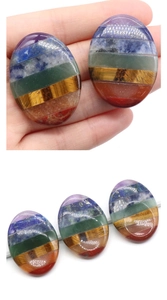 Macro detail of oval seven chakra worry stones showing colorful natural layers and smooth texture