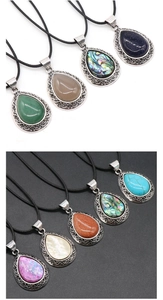 Macro detail of teardrop gemstone pendants featuring abalone shell and filigree silver base