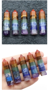 Detailed view of polished hexagonal seven chakra healing crystal point wand with hand