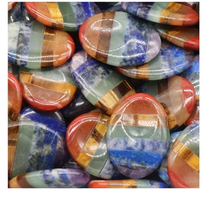 Macro close-up of colorful seven chakra worry stones with polished stacked crystal layers