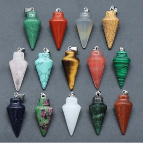Detailed assortment of conical natural stone pendants with silver metal bails on gray texture