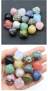 Macro view of mini gemstone planets with planetary rings held in hand for size comparison