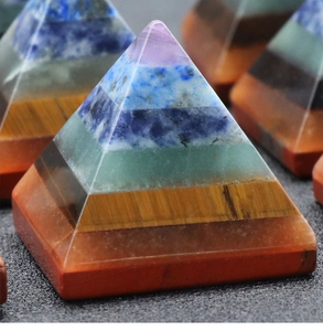 Macro detail of natural seven chakra healing crystal pyramid with layered gemstones