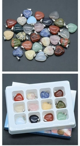 Detailed set of 12 natural semi-precious stone heart pendants in a white display tray