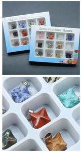 Detailed macro view of Merkaba semi-precious stone pendants in a 12-grid white display box