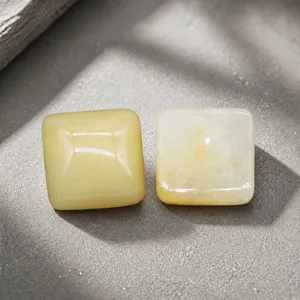 Detailansicht von zwei quadratischen Natursteinen aus gelber Jade mit glattem Ölglanz-Finish
