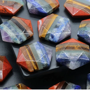 Dettaglio macro di una pietra chakra esagonale a più strati con cristalli naturali colorati
