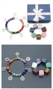 Gros plan d'un bracelet de chakra et pierres naturelles polies dans un coffret cadeau