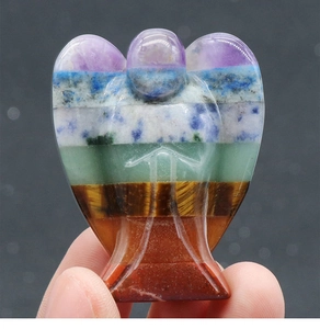Handheld view of seven chakra natural stone angel statue with polished crystal layers