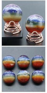 Macro shot of 7 Chakra natural crystal sphere with layered gems on a rose gold spiral stand
