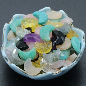 Faceted natural amethyst and quartz moon-shaped pendants in a decorative porcelain bowl