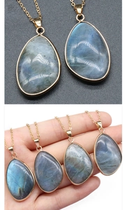 Détail macro du pendentif labradorite en goutte avec bordure dorée et reflets bleus