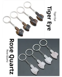 Detail view of axe-shaped pendants in tiger eye stone and pink quartz for keychains