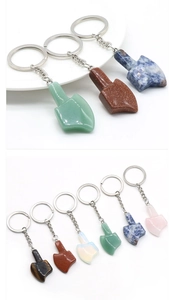 Detail view of assorted natural crystal mini axe keychains with silver metal rings