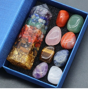 Detailed close-up of a 7-chakra crystal hexagonal column with raw healing stones in a gift box