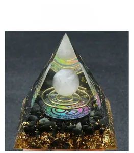 Macro detail of Orgone energy pyramid with crystal ball, metal coil, and obsidian stones