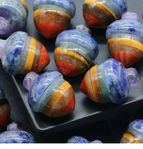 Detailed close-up of acorn-shaped natural crystal pendants with seven chakra stones