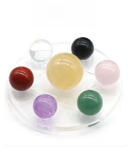 Detailed top view of seven natural crystal spheres in various colors on a clear base