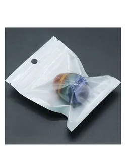 Detailed view of layered chakra egg stone in clear OPP packaging on grey surface