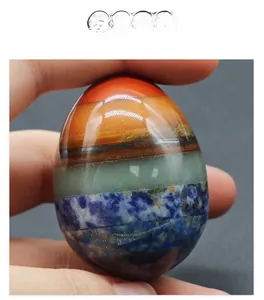 Close-up of a 48mm chakra crystal egg with seven layers of colorful polished gemstones