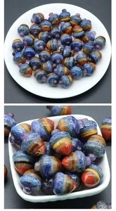 Macro detail of acorn-shaped crystal pendant charms in stacked multi-color gemstone layers