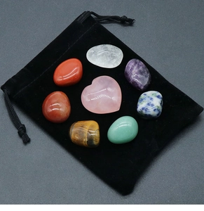 Detailed macro view of healing crystal set with pink heart stone and black velvet pouch