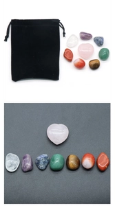 Detail of healing set with heart pink quartz and seven colorful chakra tumbled stones