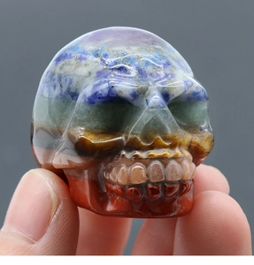 Detailed view of hand-carved multi-color natural crystal skull sculpture with smooth finish